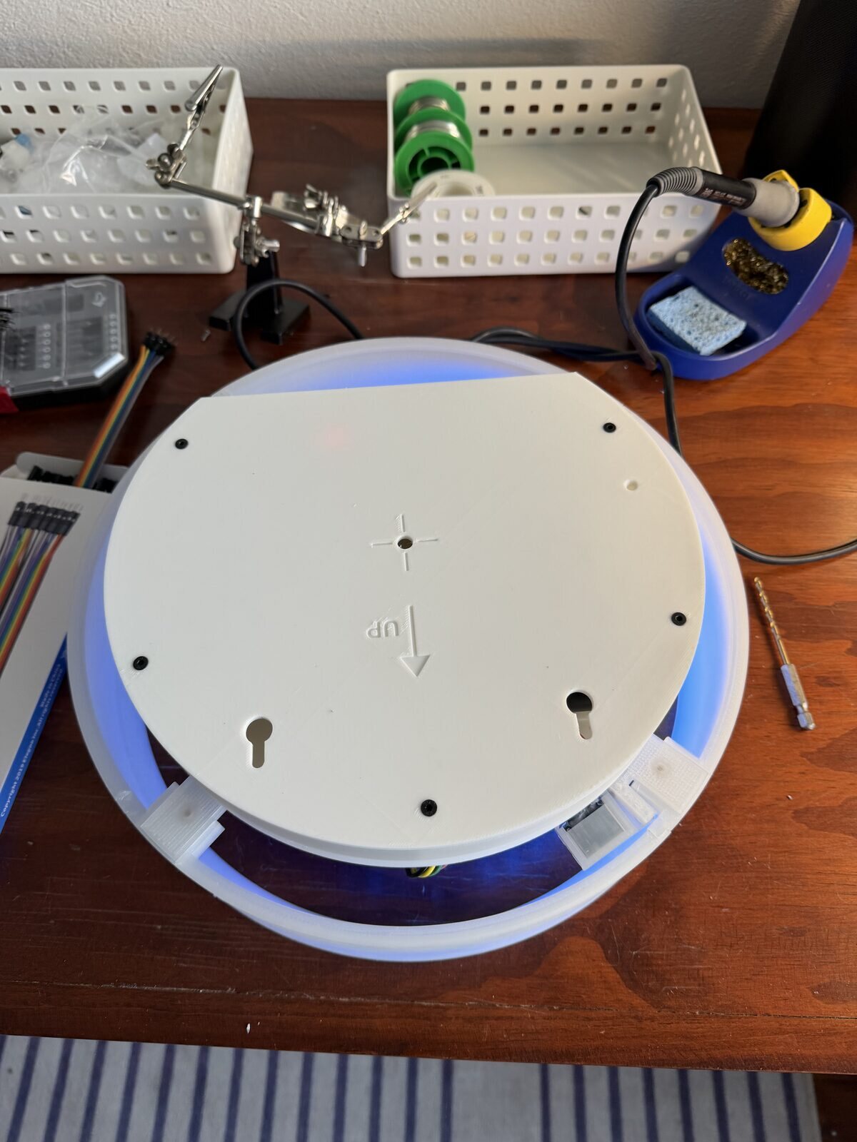 The back of the piece with its lid on, blue light leaking around the edge