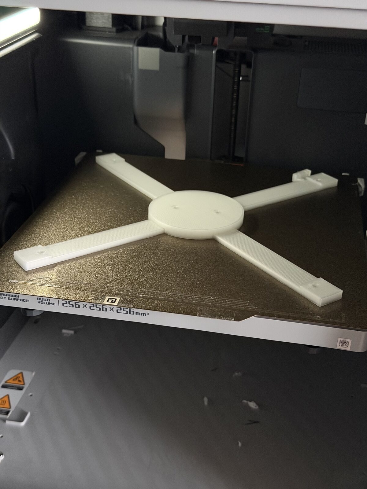 A clear printed four-armed spider on the printer bed
