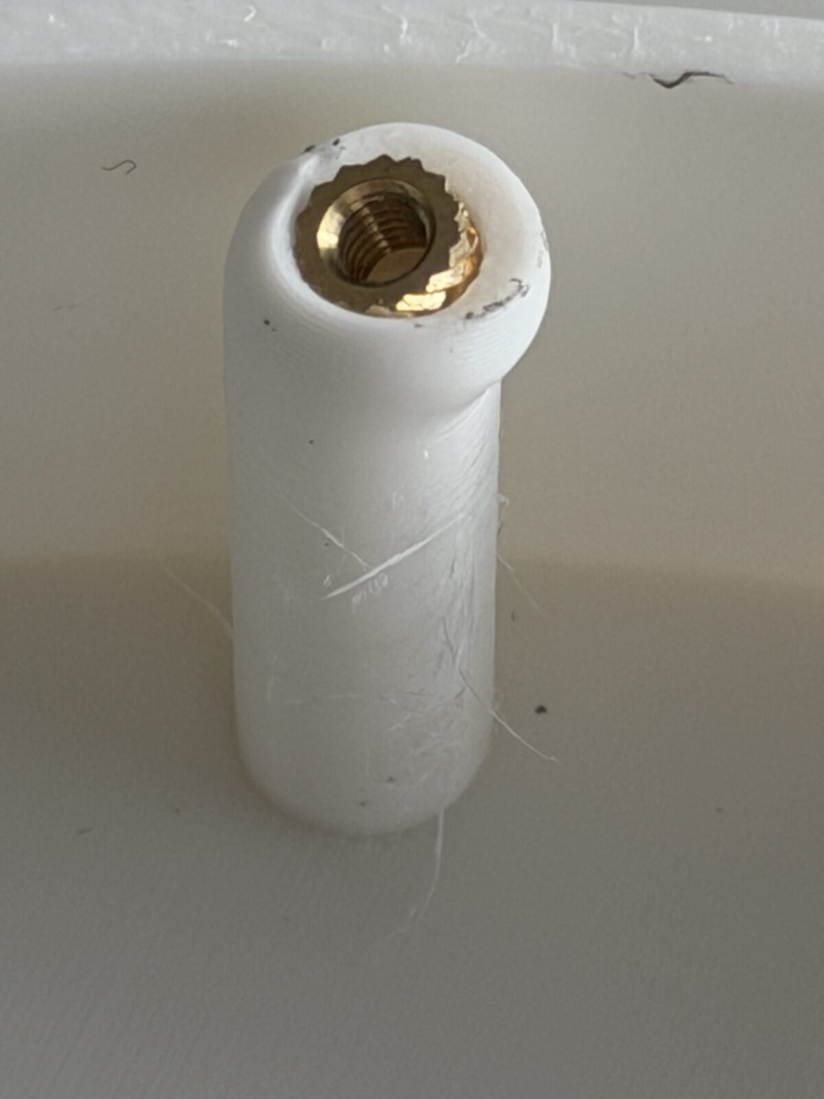 A printed post pushed out of shape around a brass insert