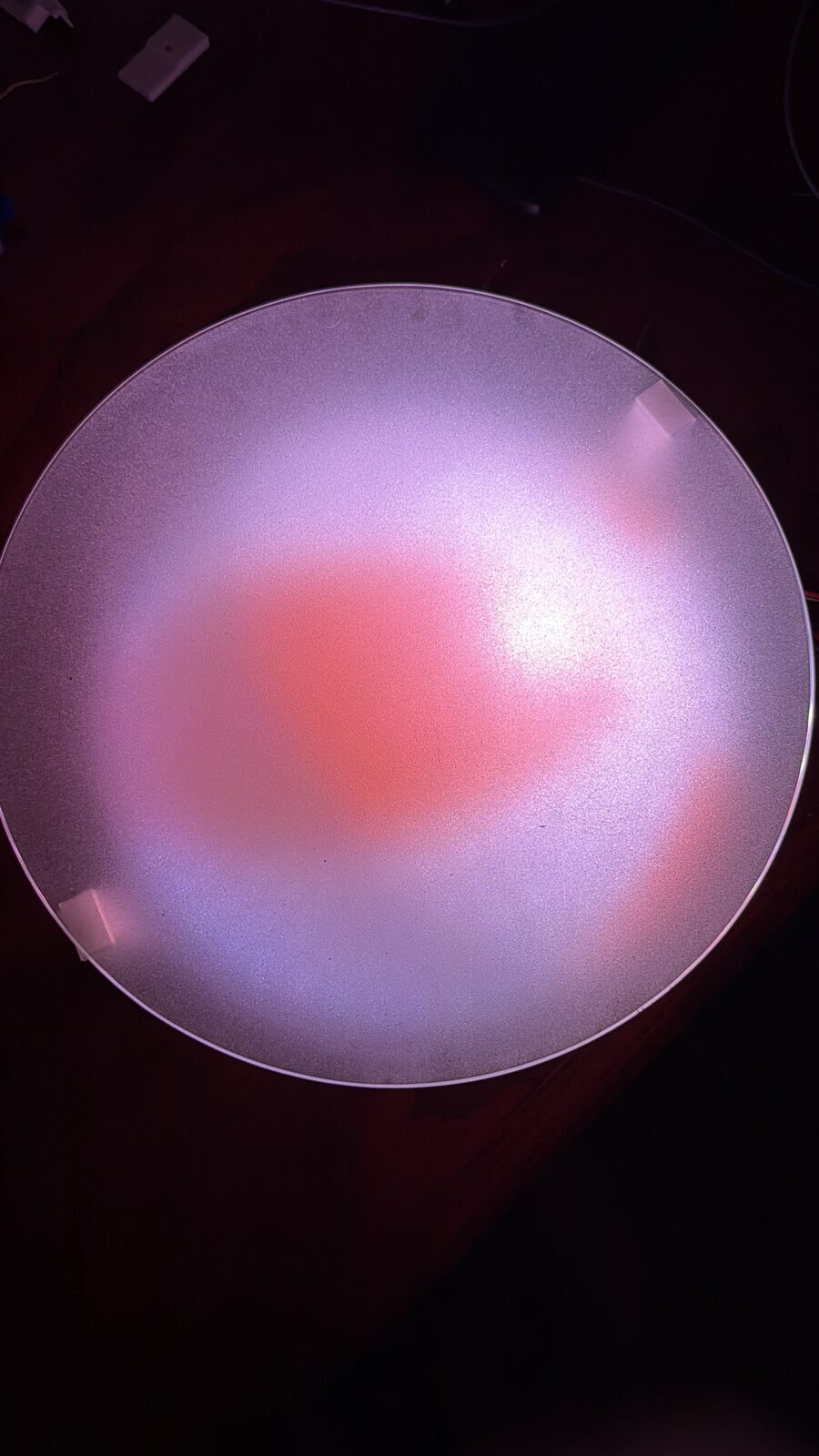 A warm orange pattern glowing through frosted glass on the bench