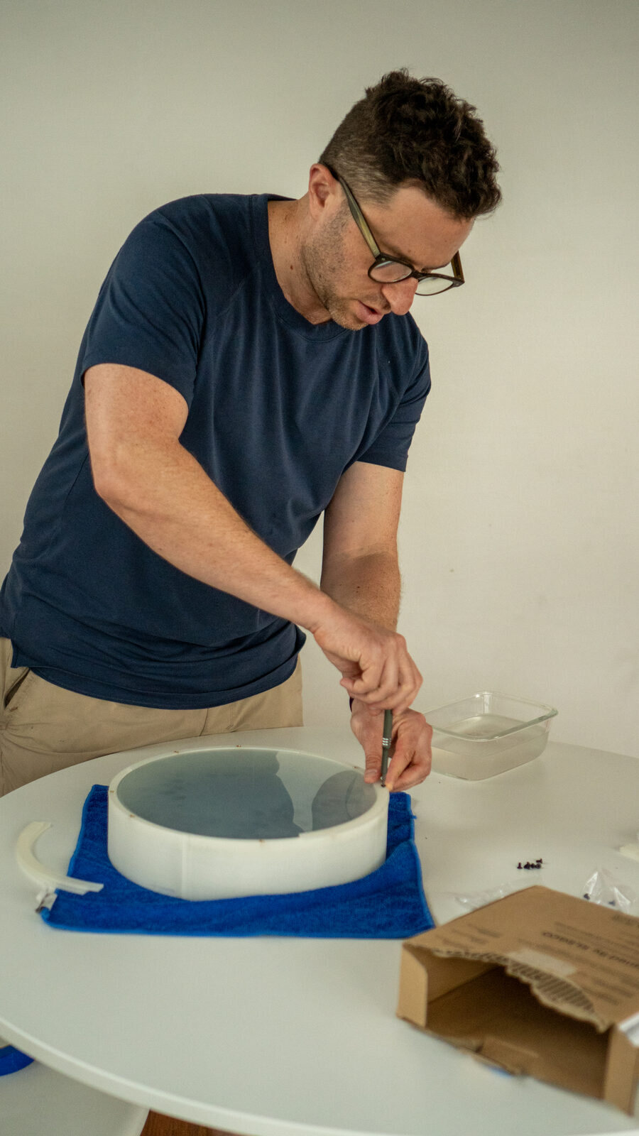 Dan screwing the ring onto the clear wall, the frosted glass in place