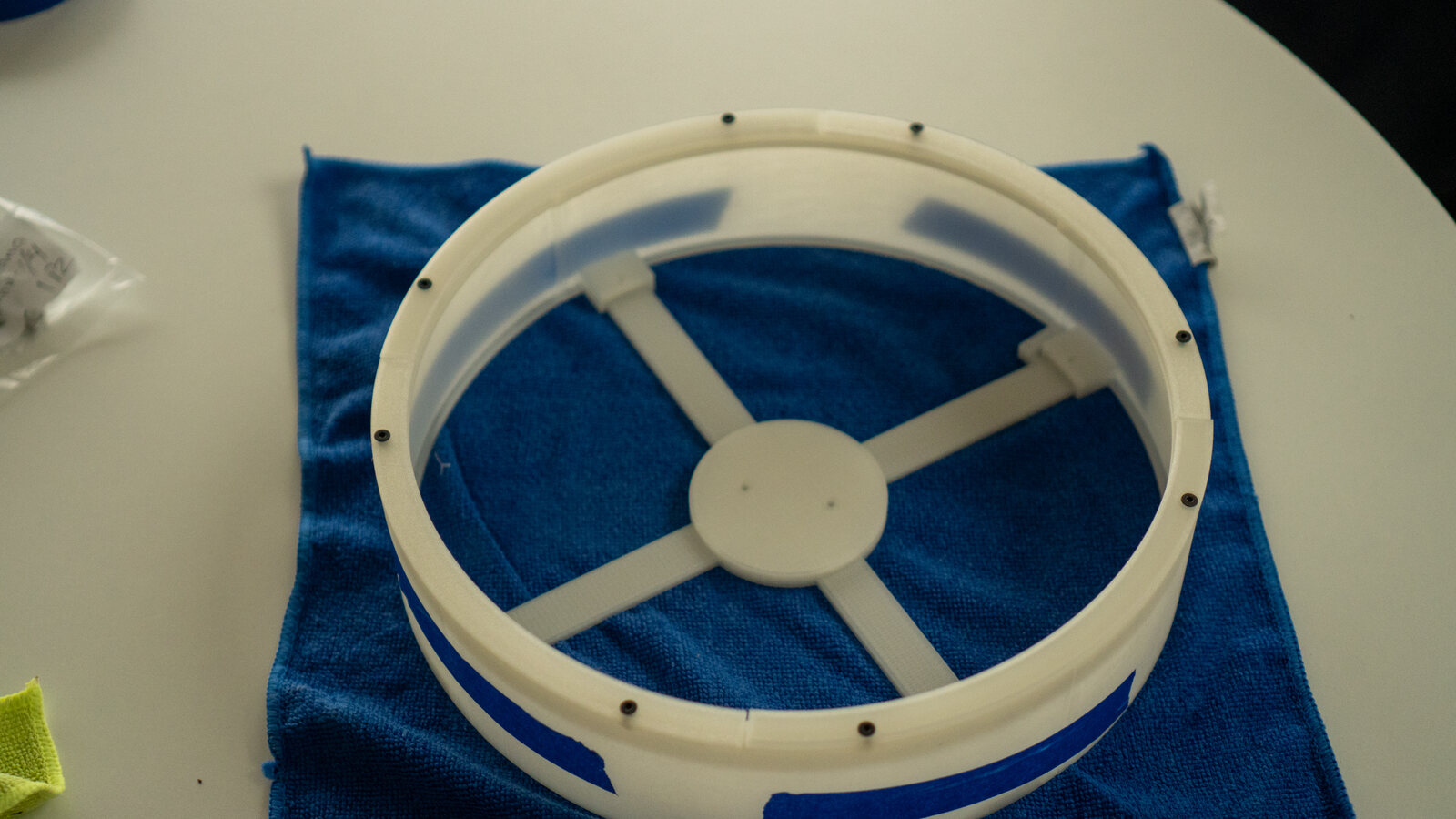 The wall ring from above, tape across the seams, the spider inside