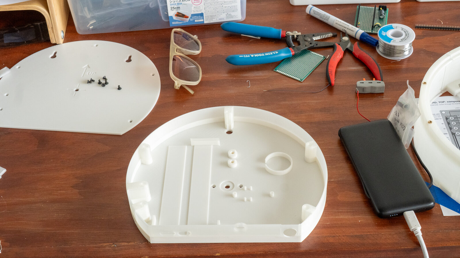 The back box on a desk with tools and parts around it