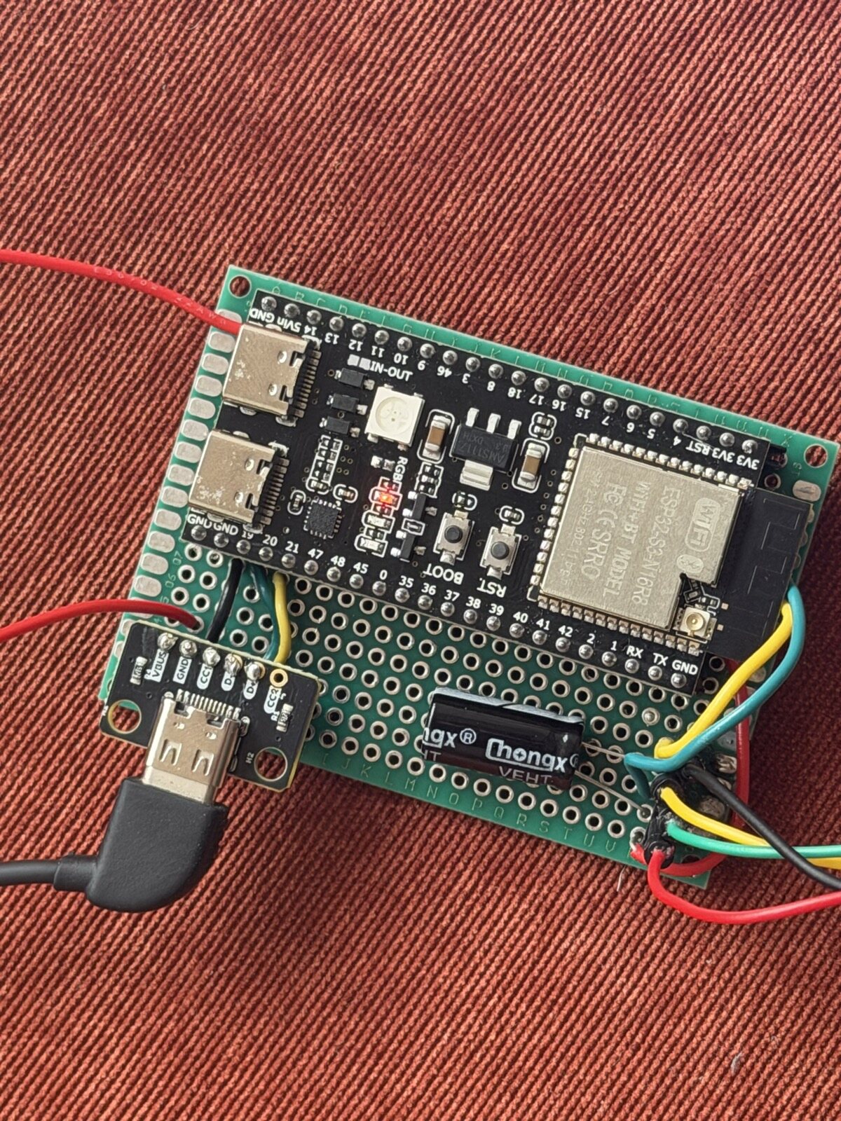 A perfboard with an ESP32 and cables coming straight off it