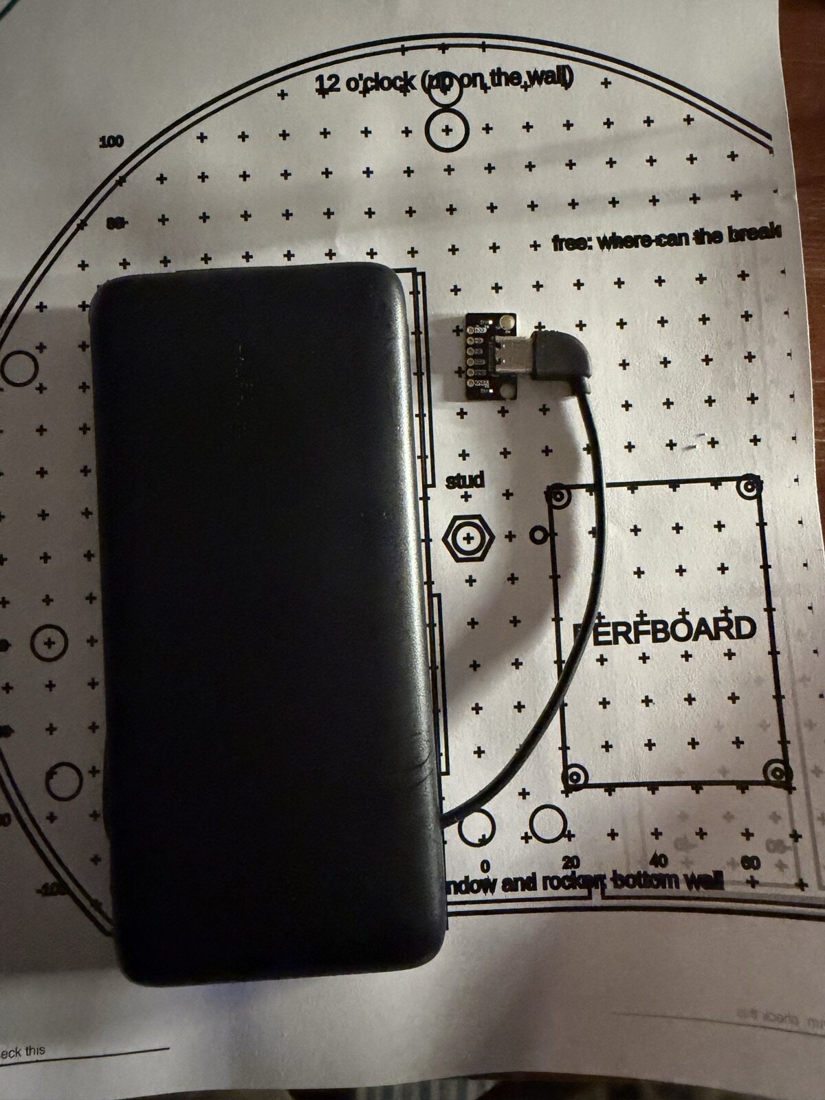 A battery and cable laid on a printed 1:1 floor plan