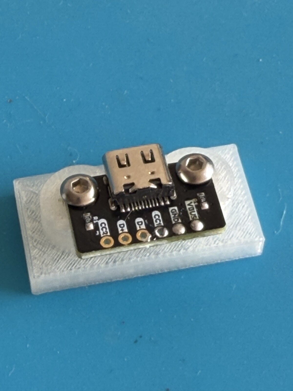 A USB-C board screwed onto clear printed posts